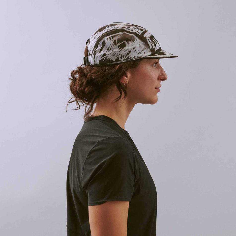 Side view of a model wearing the VÅGA Unisex Scribble Cap 2.0 in the Black/White colourway.