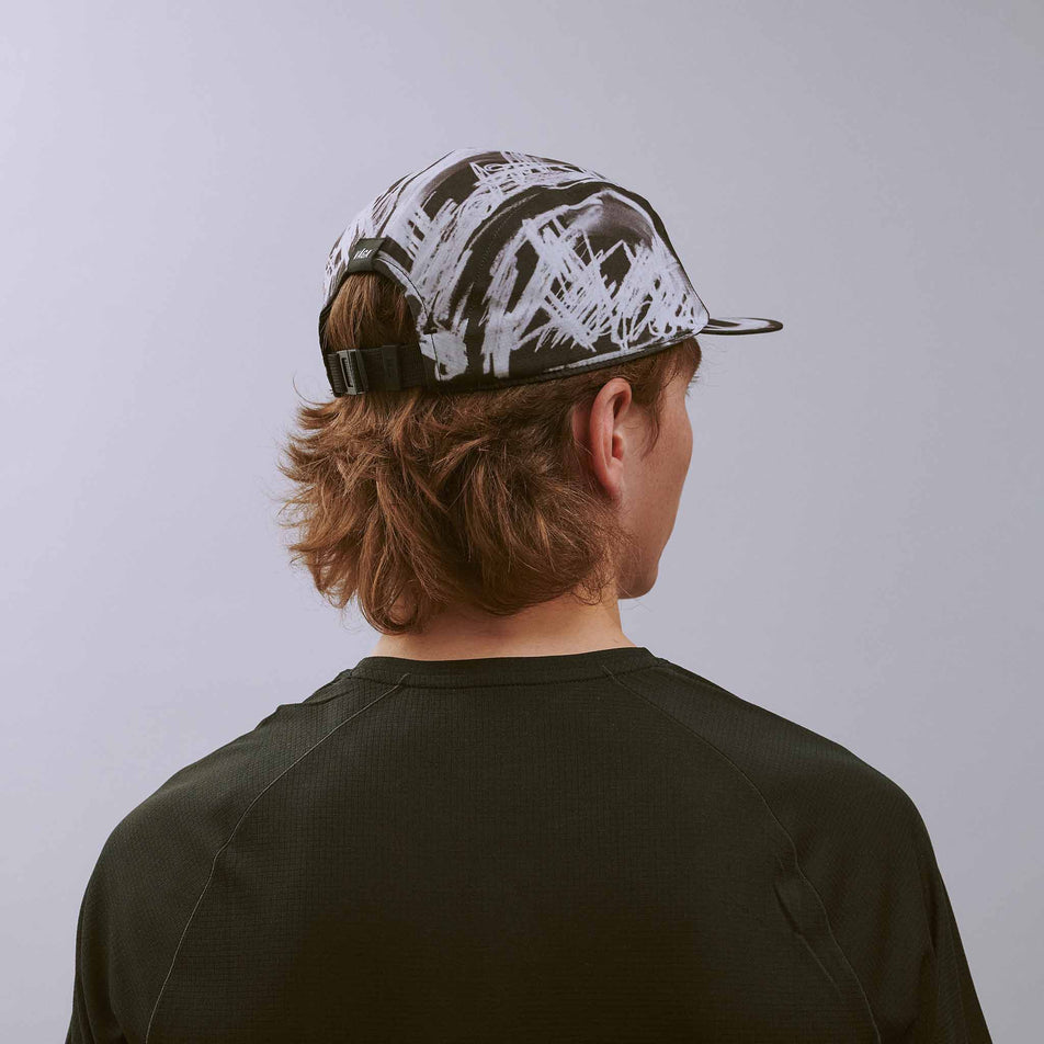 Back view of a model wearing the VÅGA Unisex Scribble Cap 2.0 in the Black/White colourway.