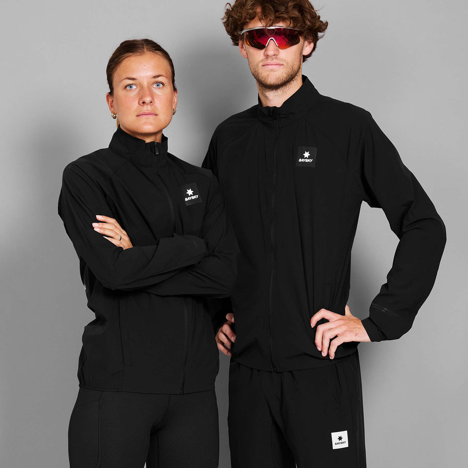 A male and female model wearing the the SAYSKY Men's Clean Pace Flex Jacket in the Black colourway. (8731609825442)