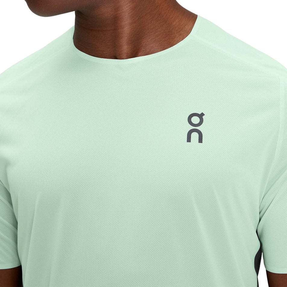 Close-up front view of a model wearing a men's On Performance T in the Creek and Black colour (7763900924066)