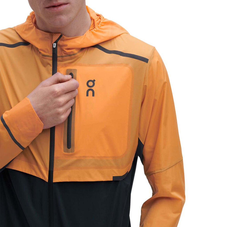 Zip pocket view of men's on weather jacket in orange (7518271242402)