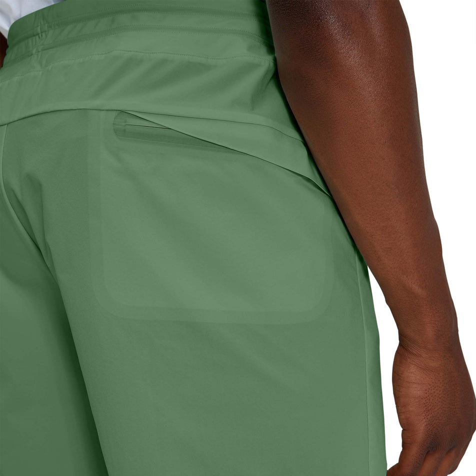 Close-up back view of a model wearing a pair of men's On Hybrid Shorts in the ivy colour (7763890536610)