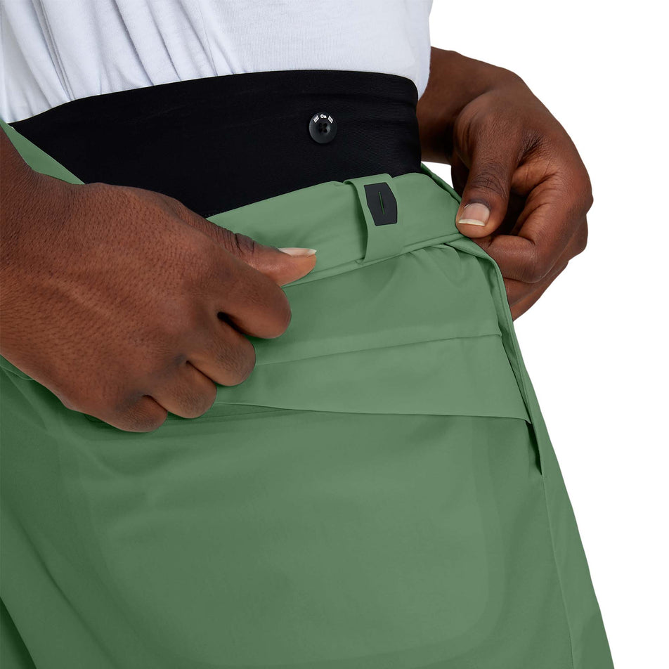 Close-up view of a model showing the detachable outer short on a pair of men's On Hybrid Shorts in the ivy colour (7763890536610)