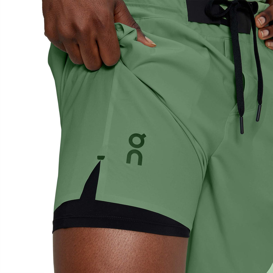 Close-up view of a model showing the inner liner on a pair of men's On Hybrid Shorts in the ivy colour (7763890536610)