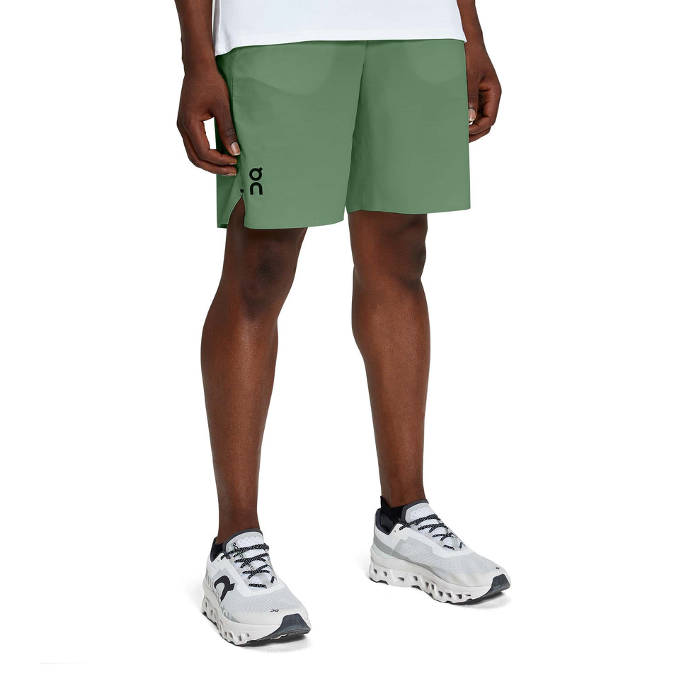 Front view of a model wearing a pair of men's On Hybrid Shorts in the ivy colour (7763890536610)