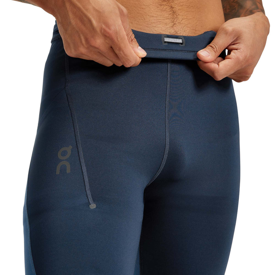 Close-up view of a model showing the inner waistband detail on a pair of men's On Performance Tights in the Navy and Denim colour (7763897155746)
