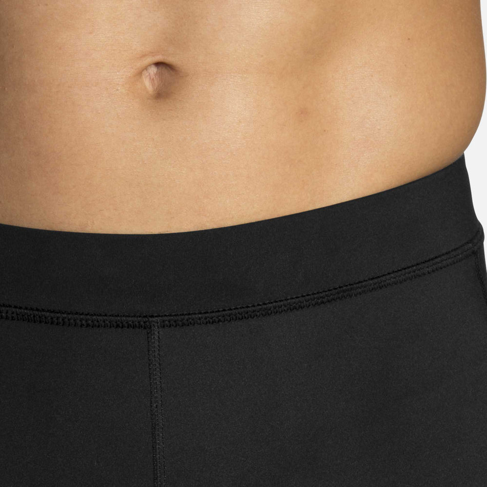 A model wearing a pair of men's Brooks Source Tight with focus on the waistband (6935063986338)