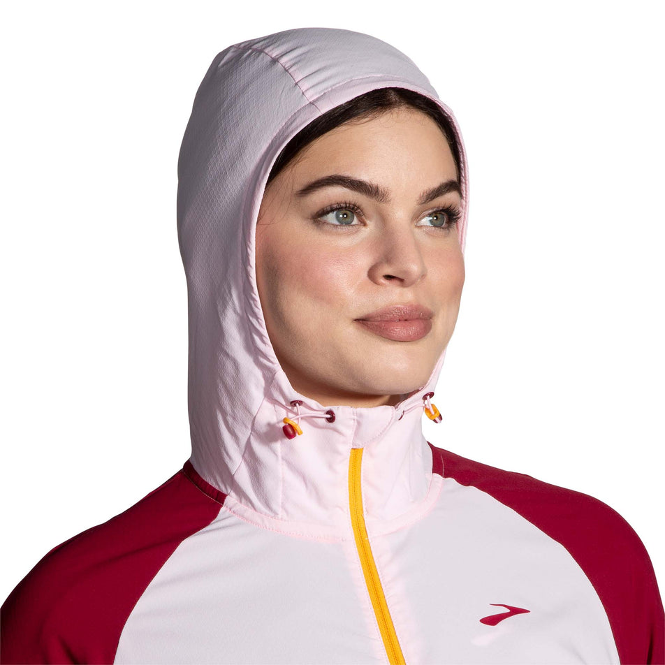 Front view of a model wearing a Brooks Women's Canopy Jacket with the hood up (7778531082402)