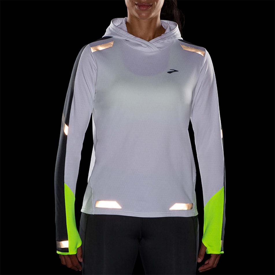 Front reflective view of Brooks Women's Run Visible Thermal Hoodie in white (7599100625058)