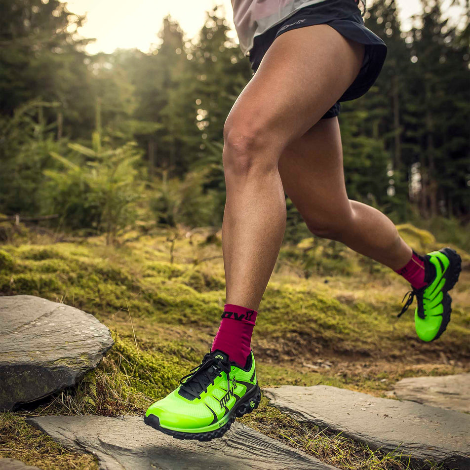 A model wearing a pair of Inov-8 TrailFly Ultra G 300 Max whilst running through a forest (6897229627554)