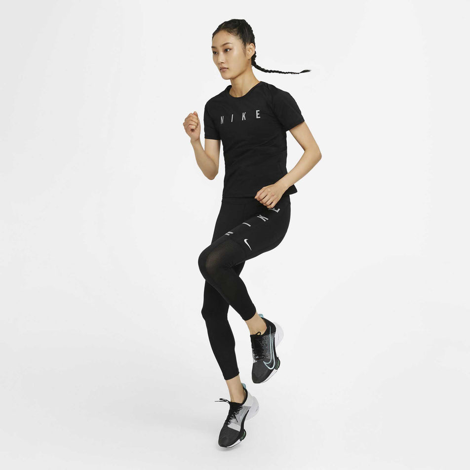 A model in a running stance and wearing the women's Nike Run Division Epic Fast Tight GX (6936939724962)