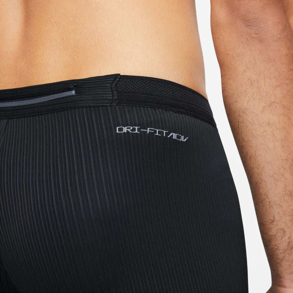 The waistband detail, and outer zipped pocket on the waistband of a pair of Nike Men's Dri-FIT ADV AeroSwift 1/2-Length Racing Tights (7876595712162)