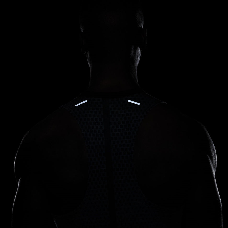 Front view of a model wearing a Nike Men's Dri-FIT ADV Techknit Ultra Running Tank - demonstrating the reflectivity on the back (7876647288994)