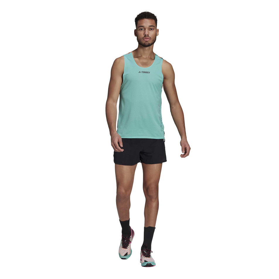 A male model walking and wearing a men's adidas TERREX AGR Singlet GFX, shorts and shoes (6929419272354)