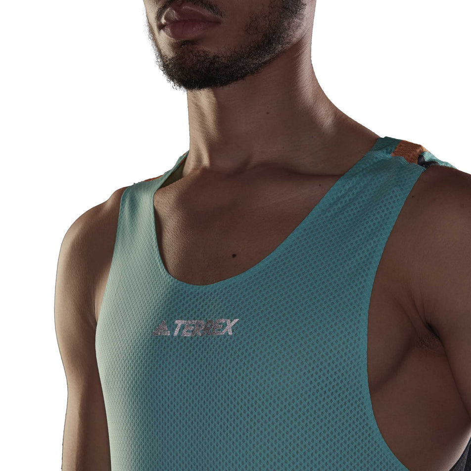 A model wearing the men's adidas TERREX AGR Singlet GFX with focus on the chest area of the garment (6929419272354)