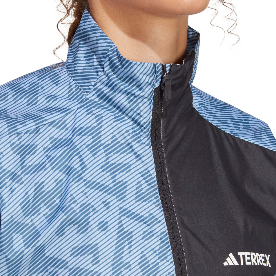 Close-up front view of a model wearing an adidas Women's Primeblue Trail Windbreaker Print - upper body section (7765651259554)