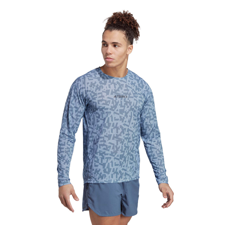 Front view of a model wearing an adidas Men's Terrex Primeblue Trail Graphic Longsleeve (7766877962402)