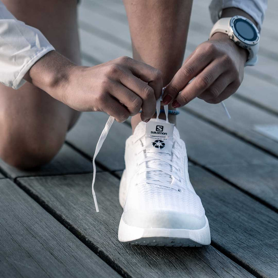 Person tying shoelace of Salomon Unisex INDEX.01 running shoe (6888669937826)