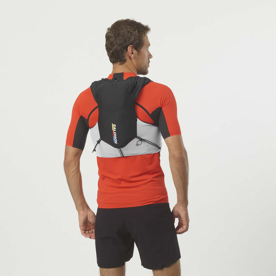 Rear model view of Salomon Unisex ADV Skin 5 Race Flag Running Vest in black. (7776526762146)