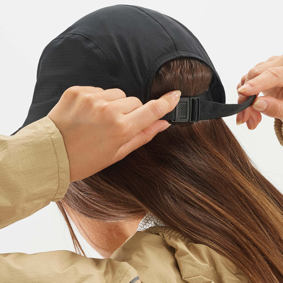 Rear clasp female model view of Salomon Unisex Bonatti WP Five P Running Cap in black. (7777715486882)