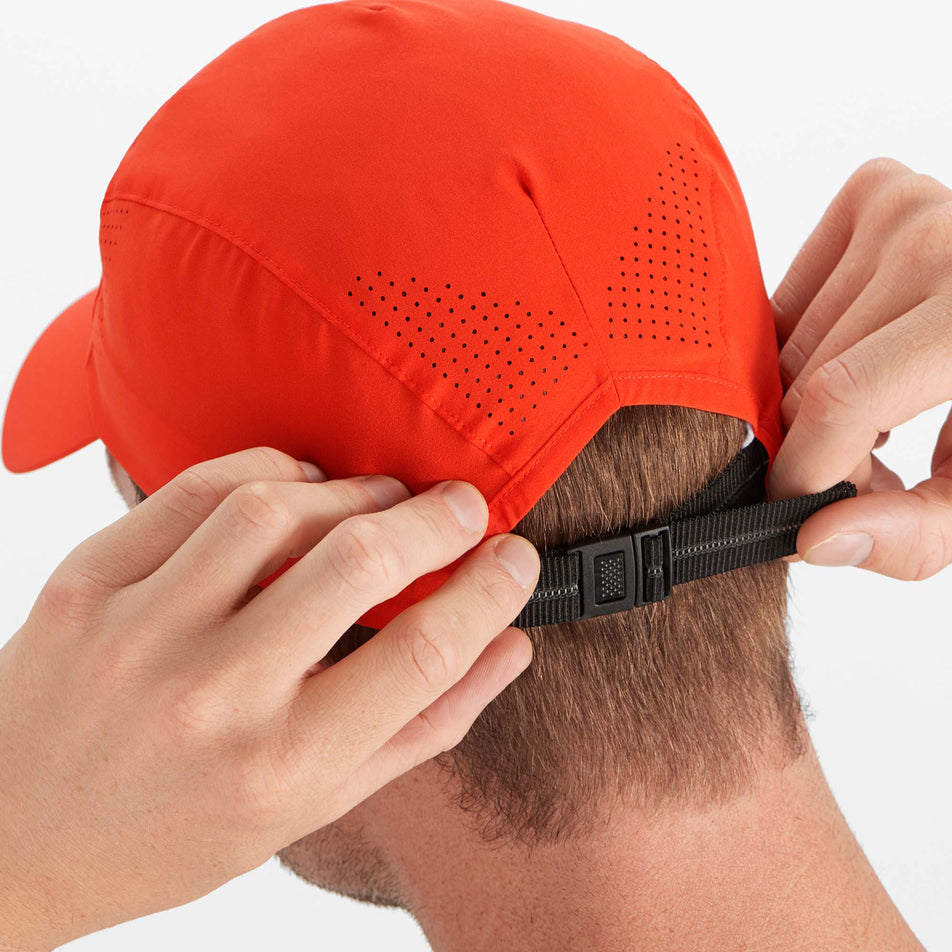 Male model rear clasp adjustment view of Salomon Unisex Cross Running Cap in red. (7777436696738)
