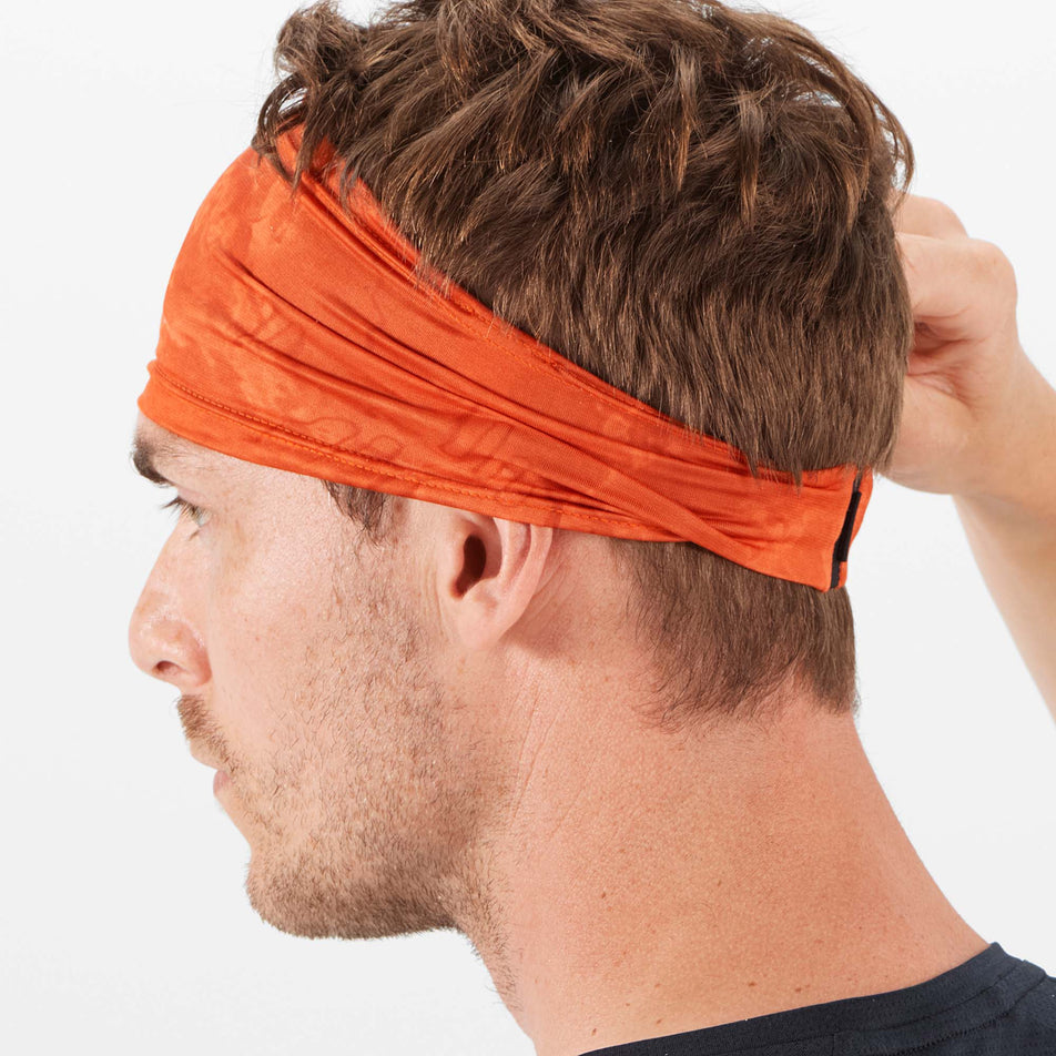 Rear angled model view of Salomon Unisex Sense Running Headband in orange. (7777688977570)