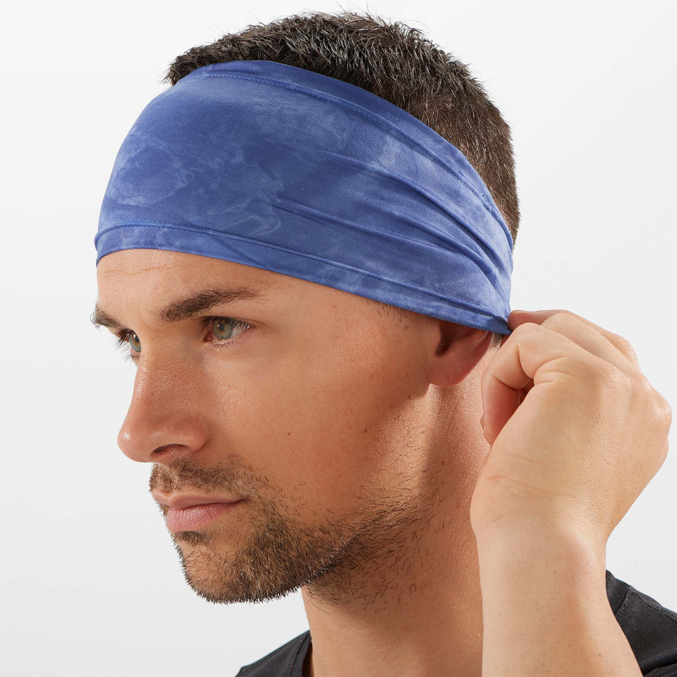 Front angled male model view of Salomon Unisex Sense Running Headband in blue. (7777695891618)
