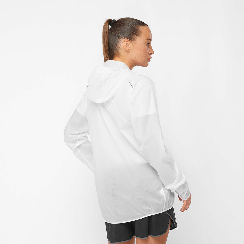 Back view of a female model wearing a Salomon Unisex Bonatti Aero Wind Jacket, in the White/Deep Black colourway (7889368514722)