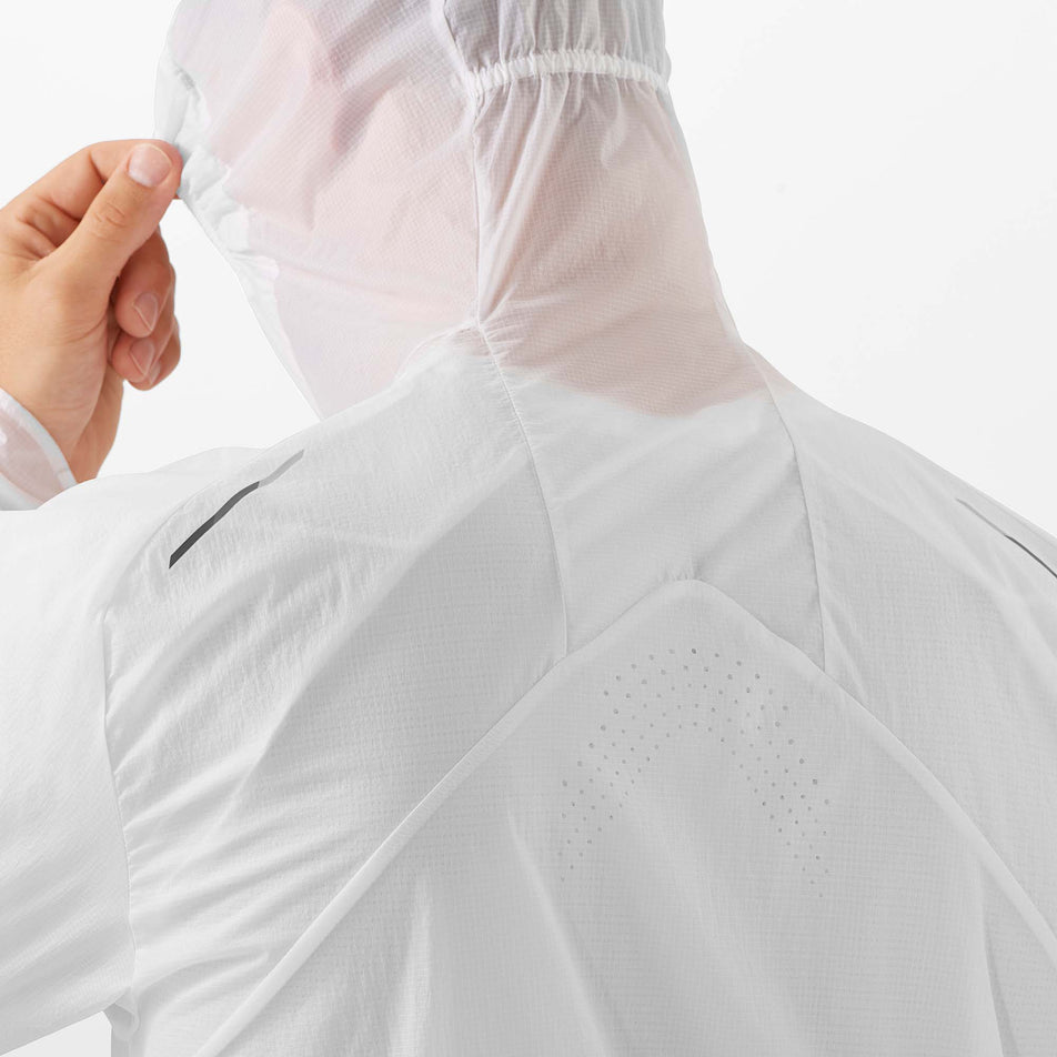 Close-up of a male model demonstrating the hood on a Salomon Unisex Bonatti Aero Wind Jacket, in the White/Deep Black colourway (7889368514722)