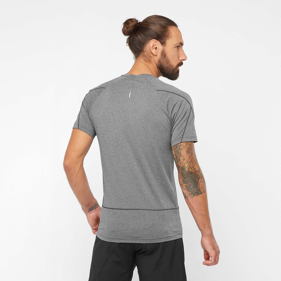 Back view of a model wearing a Salomon Men's Cross Run Short Sleeve T-Shirt, in the Deep Black/Heather colour (7889286824098)