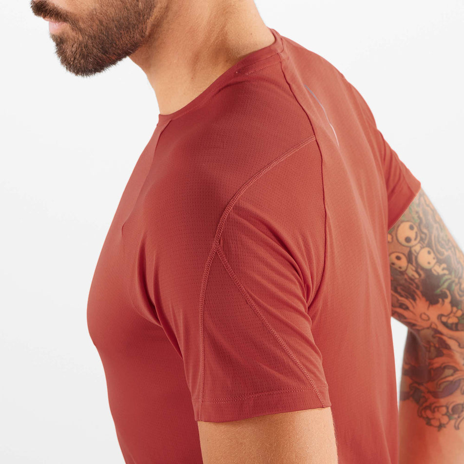 Close-up view of the stitching detail on the left shoulder of a Salomon Men's Cross Run Short Sleeve T-Shirt - in the Hot Sauce colourway, being worn by a model (7889329488034)