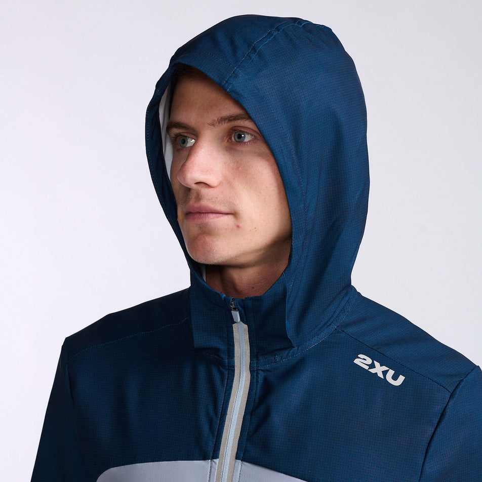 Close-up front view of a model wearing a 2XU Men's Aero Jacket. Upper body section with the hood up. (7778521153698)