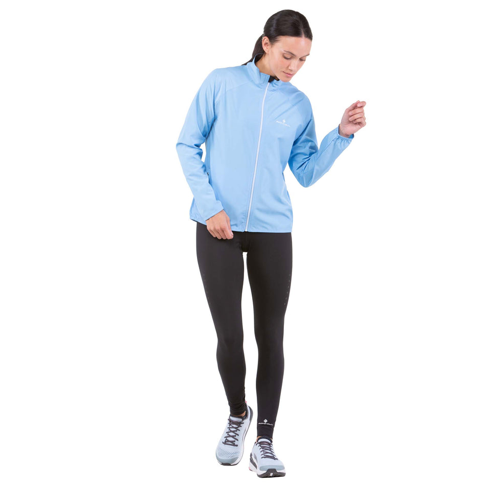Front view of a model wearing a Ronhill Women's Core Jacket in the Cornflower Blue/Bright White Colourway (7742635245730)