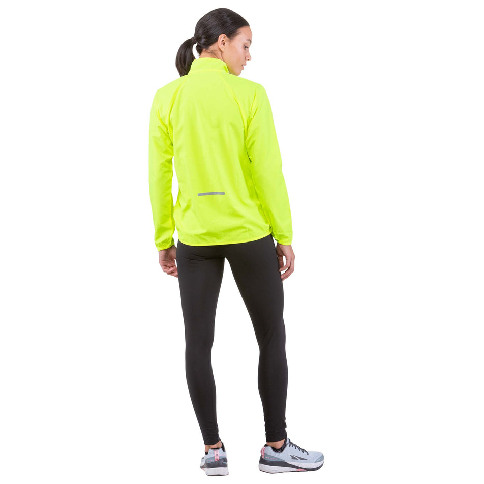 Back view of a model wearing a Ronhill Women's Core Jacket in the Fluo Yellow colourway (6907662434466)