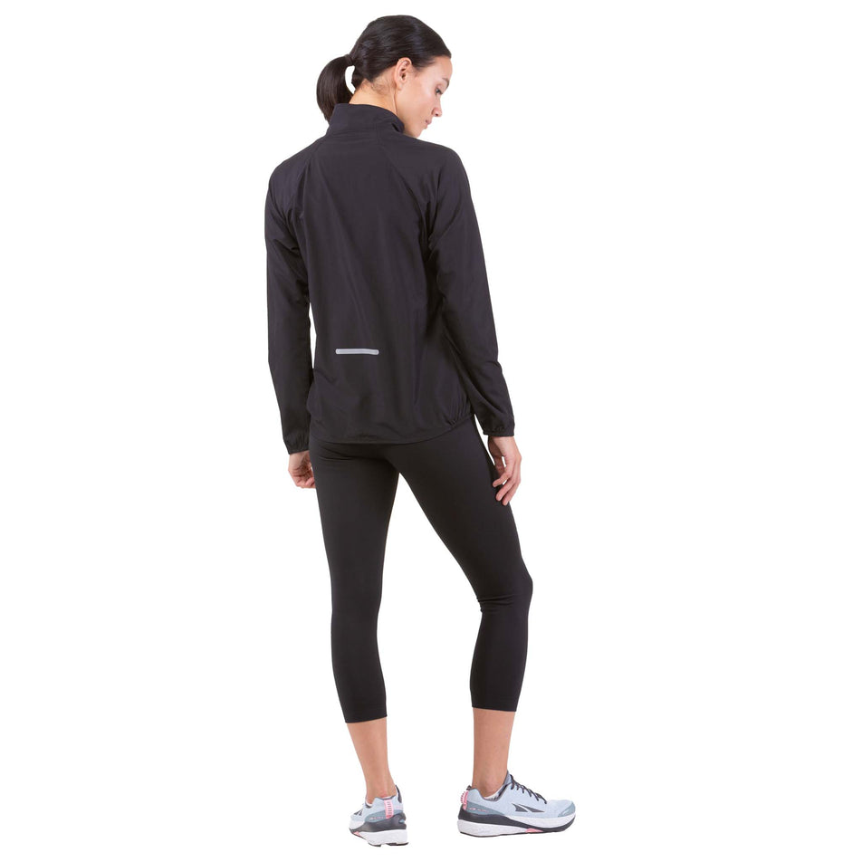Back view of a model wearing a Ronhill Women's Core Jacket in the All Black colourway (6907646214306)