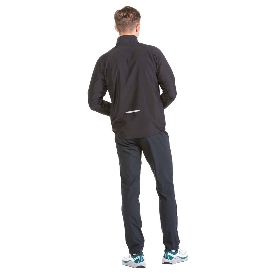 Back view of a model wearing a Ronhill Men's Core Jacket in the All Black colourway (6908243378338)