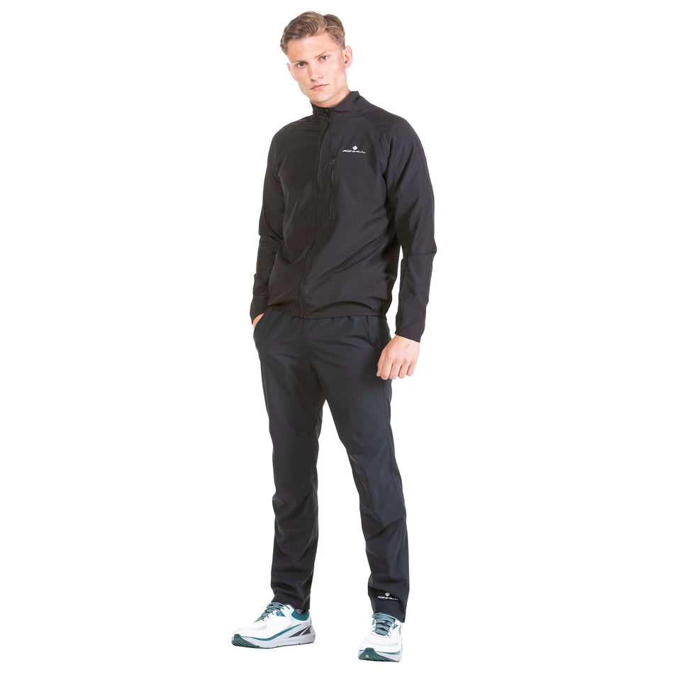 Front view of a model wearing a Ronhill Men's Core Jacket in the All Black colourway (6908243378338)