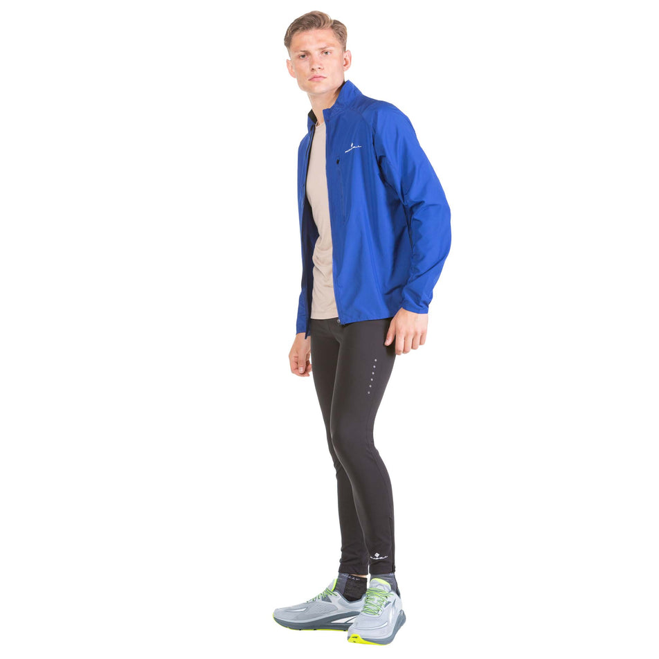 Angled front view of a model wearing a Ronhill Men's Core Jacket in the Dark Cobalt/Bright White colourway (7573999976610)