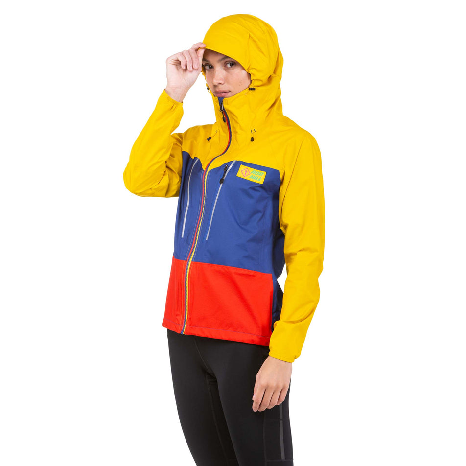 Front view of a model wearing a Ronhill Women's Tech Fortify Jacket - with the hood up - in the Dark Cobalt/Solar colourway (7746201976994)