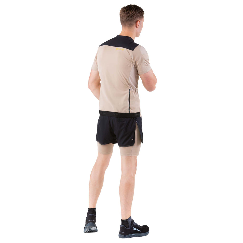 Back view of a model wearing a Ronhill Men's Tech Ultra 1/2 Zip Tee in the Latte/Black colourway (7744538149026)