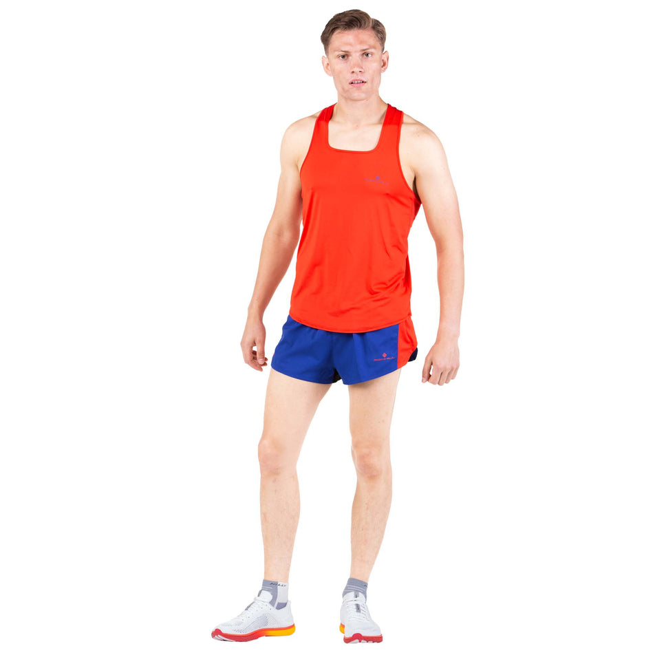 Front view of a model wearing a Ronhill Men's Tech Revive Racer Vest in the Flame/Solar colourway (7743543967906)