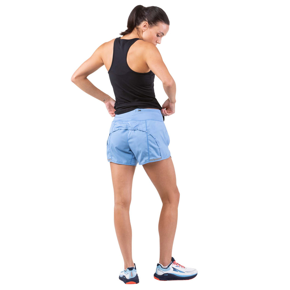Back view of a model wearing a pair of Ronhill Women's Tech Revive Shorts in the Lake Blue/Vanilla colourway (7739495776418)