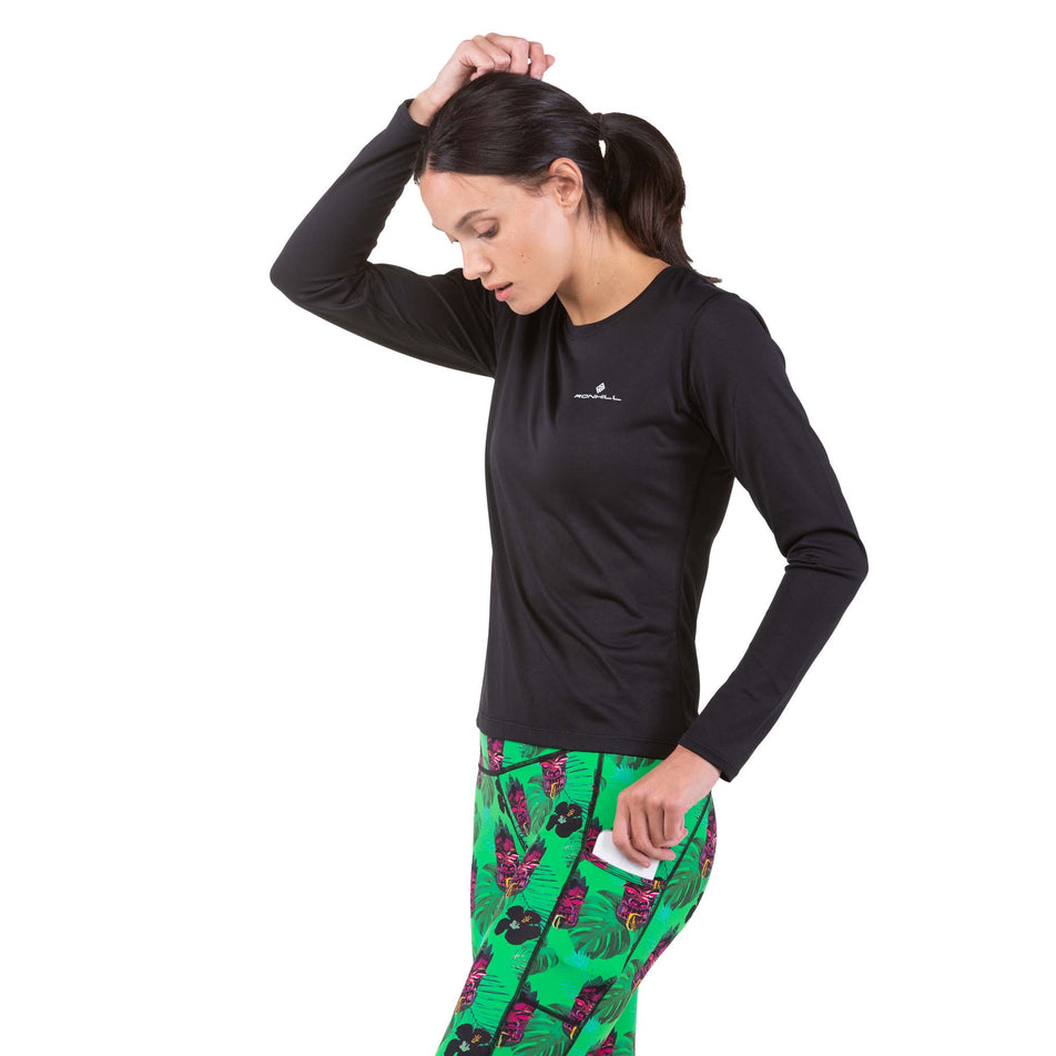 A model taking a phone out of the side leg pocket on a pair of Ronhill Women's Life Crop Tights (7746135589026)