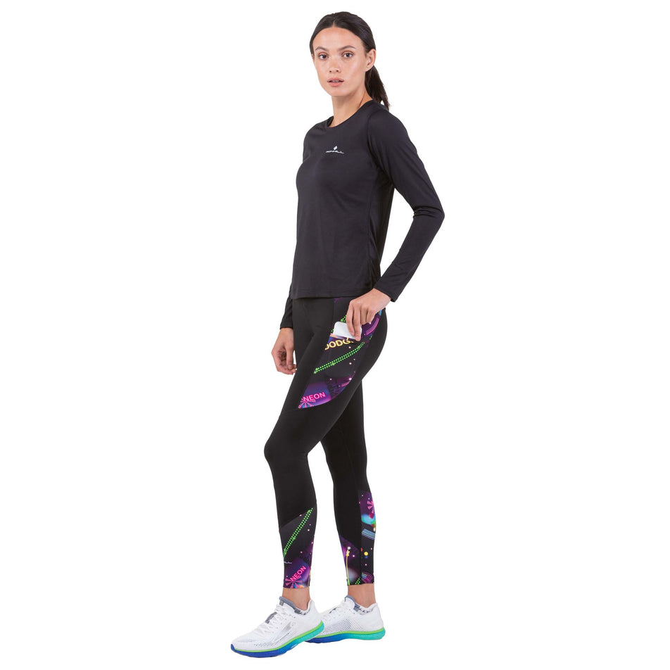 Front view of a model taking a phone out of the side leg pocket on a pair of Ronhill Women's Life Satori Tights (7745842675874)