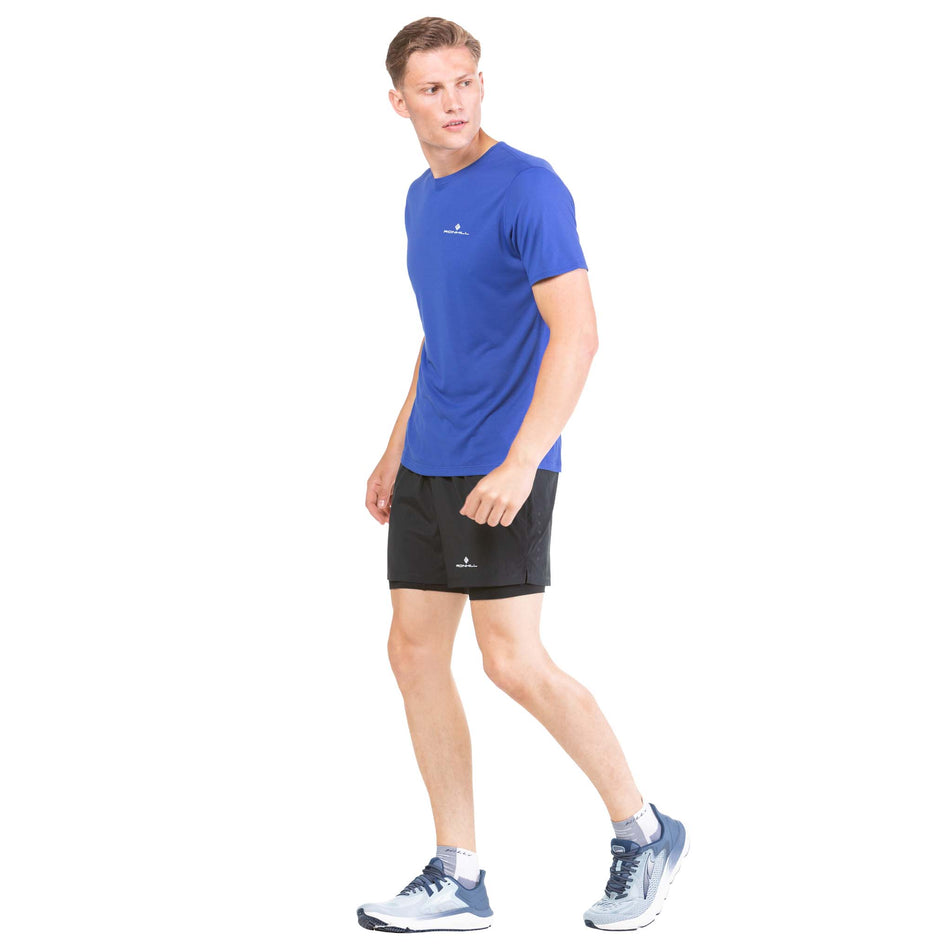Side view of a model wearing a pair of Ronhill Men's Core Twin Shorts (7742704091298)