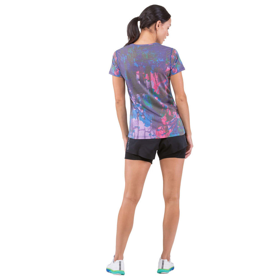 Back view of a model wearing a Ronhill Women's Tech Golden Hour Tee (7739435516066)